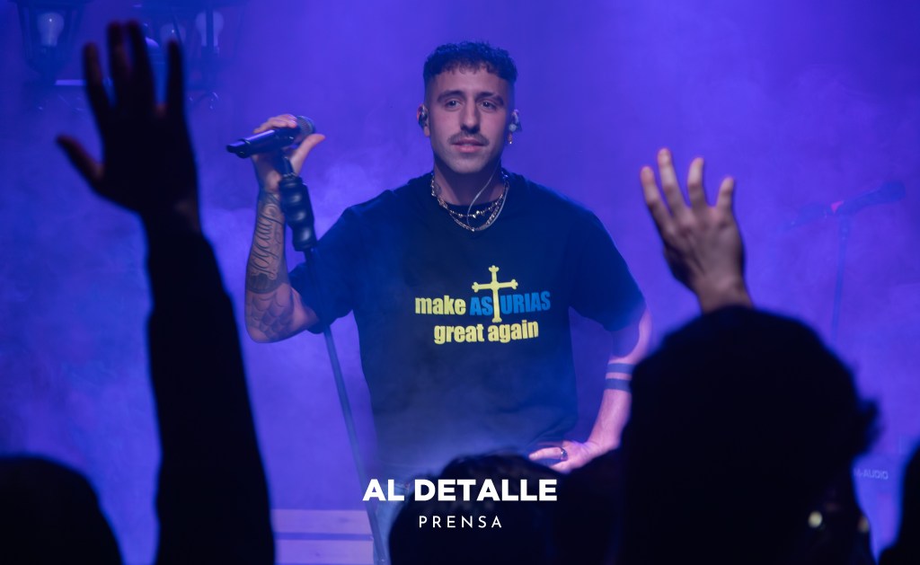 Enol mirando al público cantar vestido con una de las camisetas del merchandising.